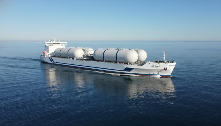 Новейший газовоз-танкер «Active» для перевозки сжиженного углекислого газа плывет по спокойному морю. На палубе видны большие грузовые танки.